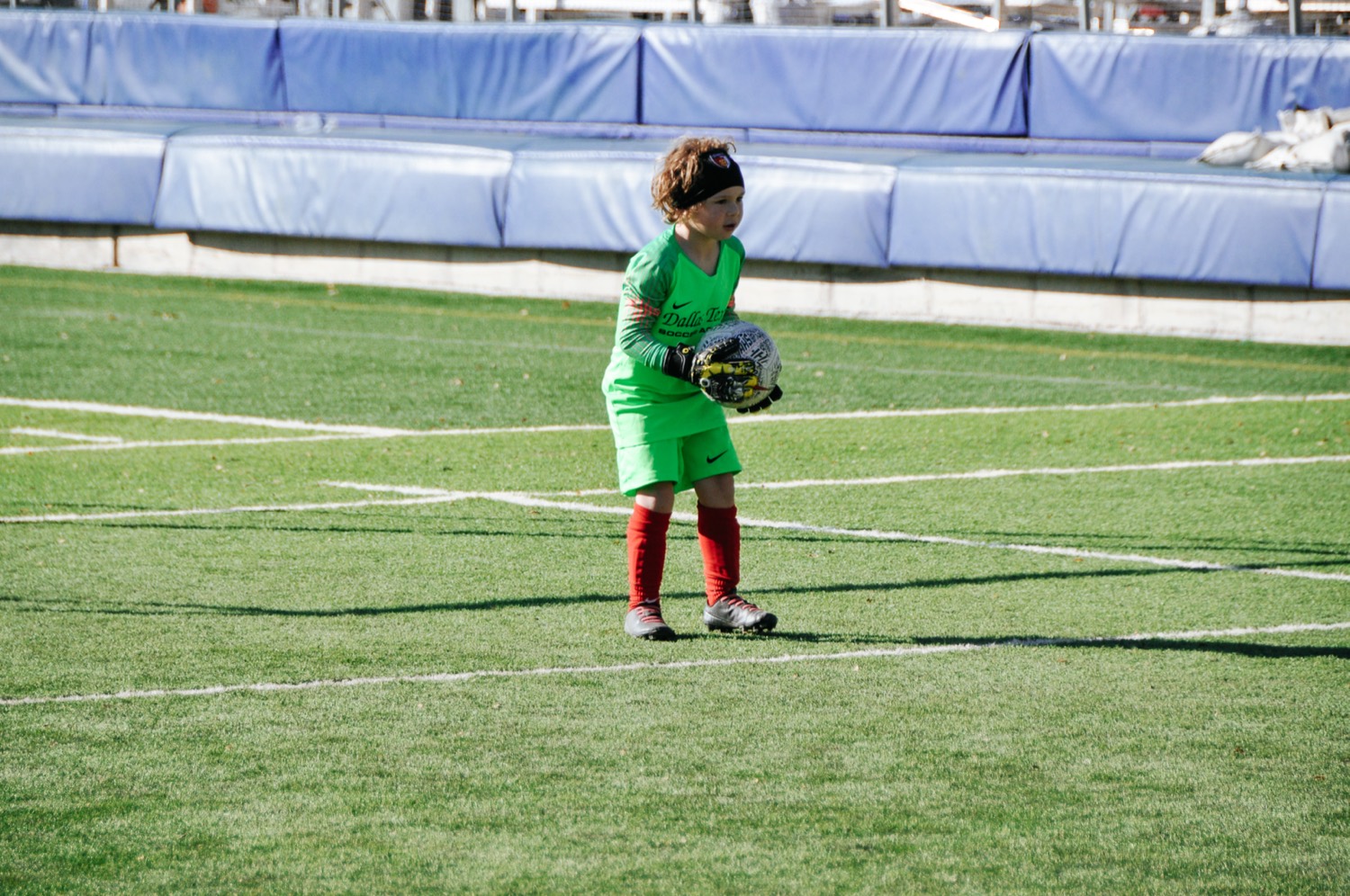 Young goalkeeper holding the ball on the field